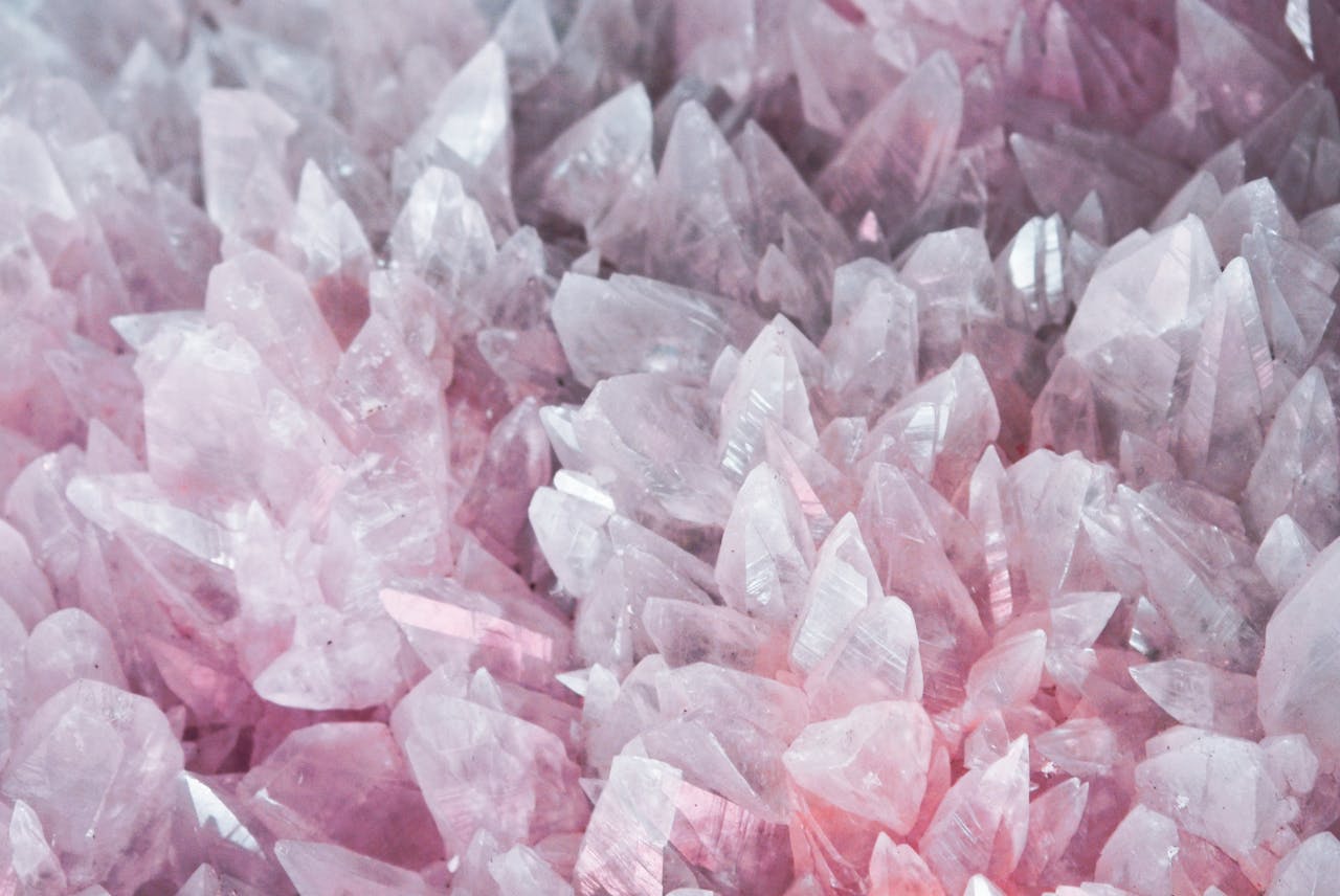 A detailed close-up of rose quartz crystals showcasing their pink hues and translucent nature.